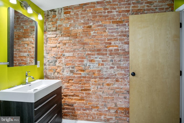 bathroom with brick wall and vanity