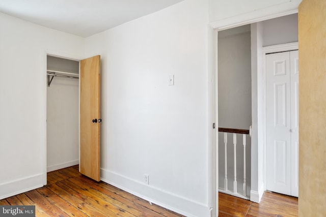 unfurnished bedroom with hardwood / wood-style flooring and a closet