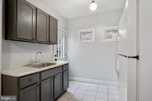 kitchen featuring sink, light tile patterned floors, and white fridge