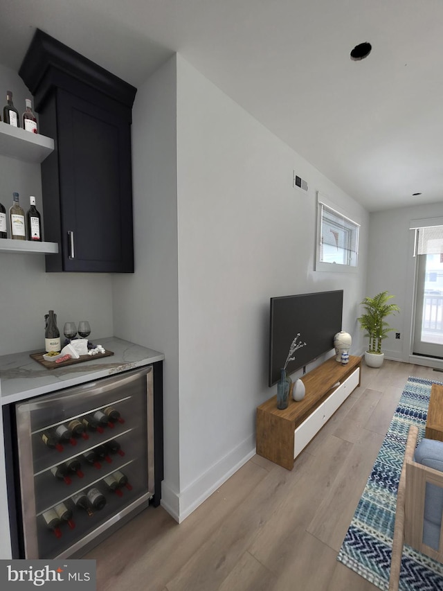 living room with indoor bar, light hardwood / wood-style flooring, and wine cooler