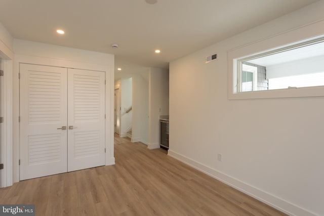 unfurnished bedroom featuring light wood-type flooring and a closet