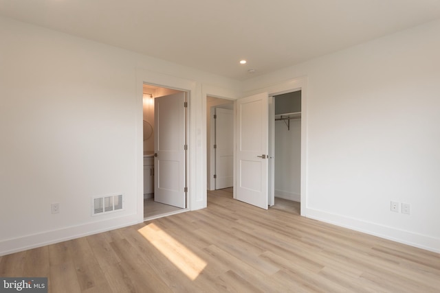 unfurnished bedroom featuring light hardwood / wood-style flooring and a closet