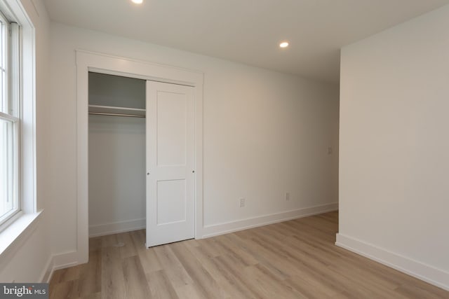 unfurnished bedroom featuring a closet and light wood-type flooring