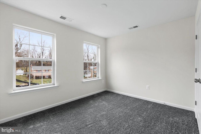 unfurnished room featuring dark colored carpet