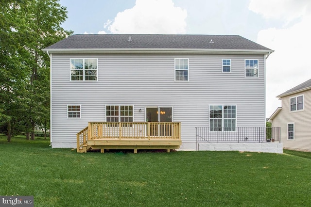 back of house featuring a deck and a lawn