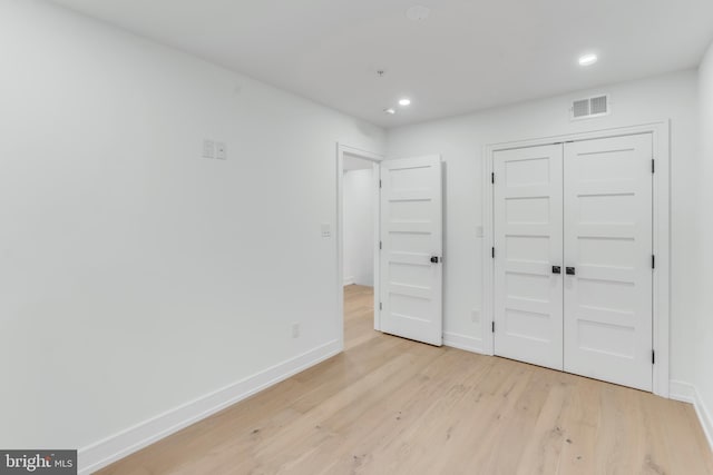 unfurnished bedroom featuring light hardwood / wood-style flooring and a closet