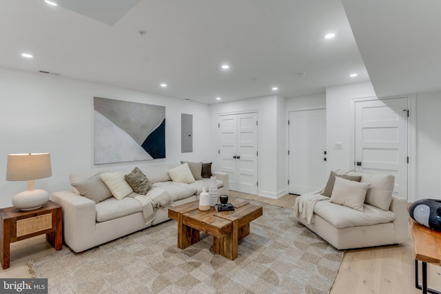 living room with electric panel and light hardwood / wood-style flooring