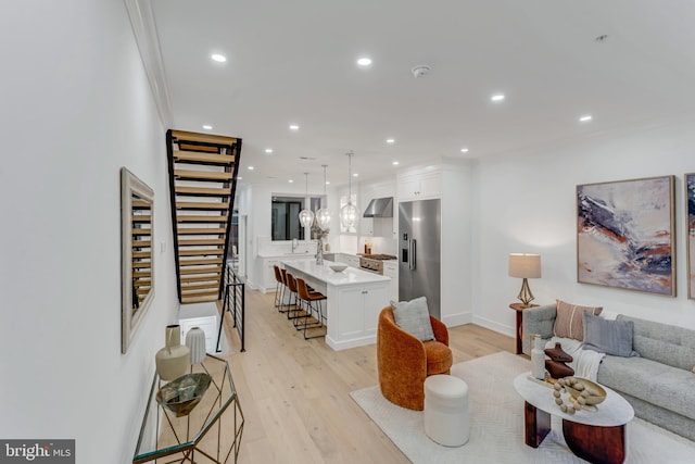 living room with crown molding and light hardwood / wood-style flooring