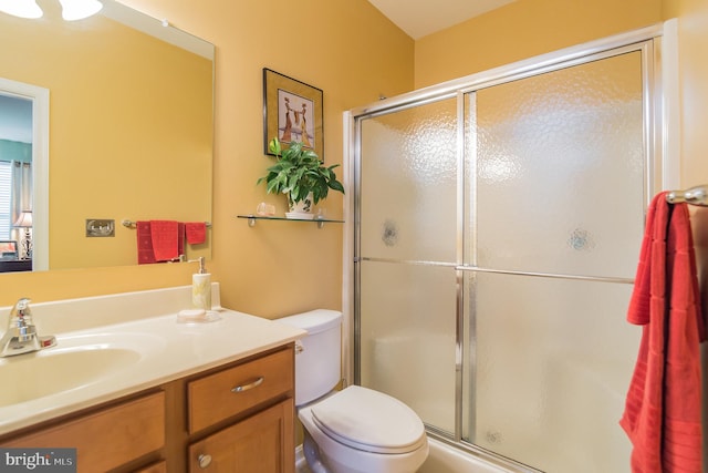 bathroom with vanity, toilet, and a shower with shower door