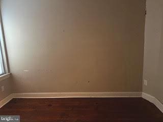 unfurnished room with dark wood-type flooring