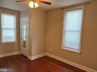 spare room with dark hardwood / wood-style floors, a healthy amount of sunlight, and ceiling fan