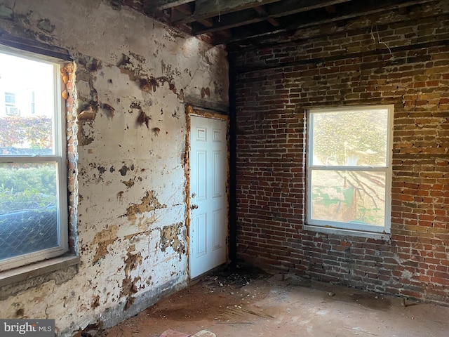 empty room featuring brick wall