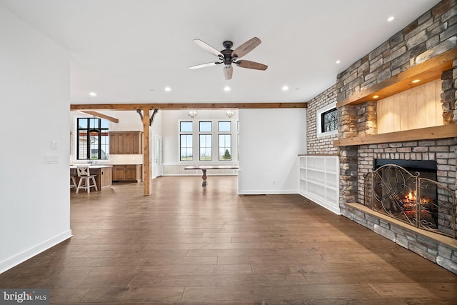 living room with a fireplace, dark hardwood / wood-style floors, ceiling fan, and beamed ceiling