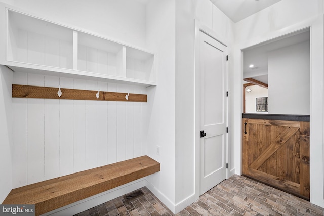 mudroom featuring wooden walls