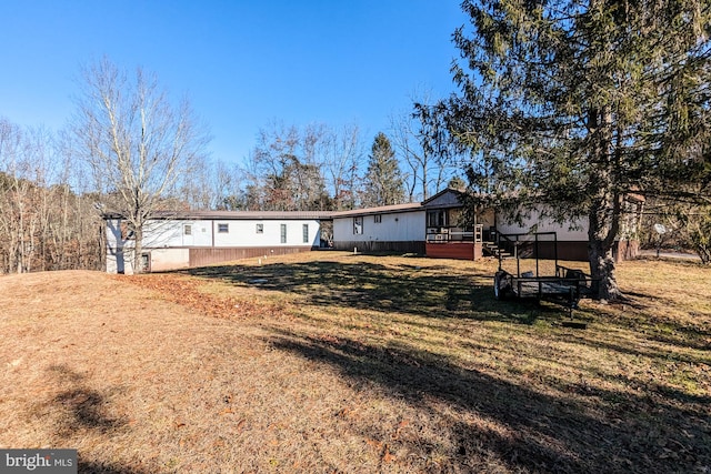 rear view of property featuring a lawn and a deck