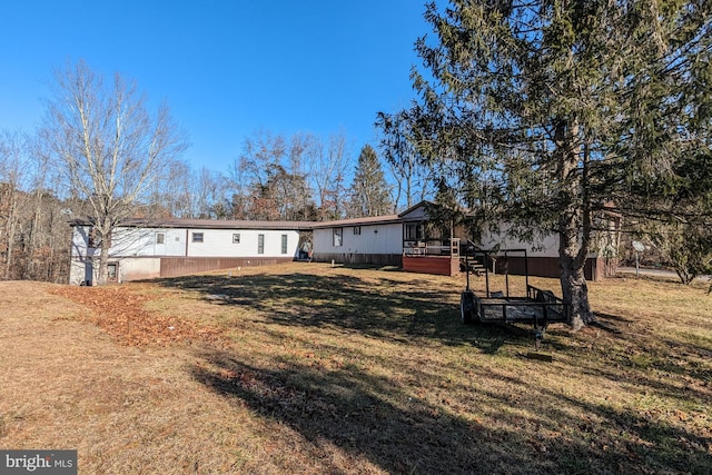 back of house featuring a deck and a lawn