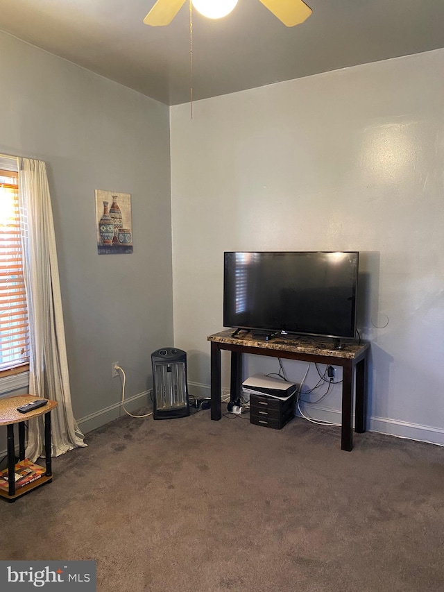 living room featuring dark colored carpet and ceiling fan