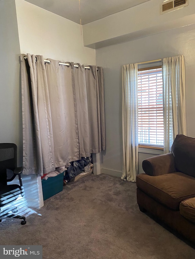 sitting room featuring dark colored carpet