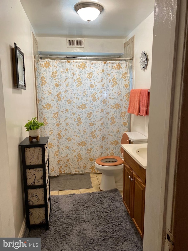 bathroom with vanity, tile patterned flooring, and toilet