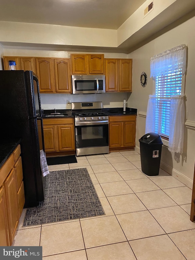 kitchen with sink, stainless steel appliances, and light tile patterned floors