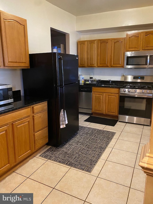 kitchen with stainless steel appliances, sink, and light tile patterned floors