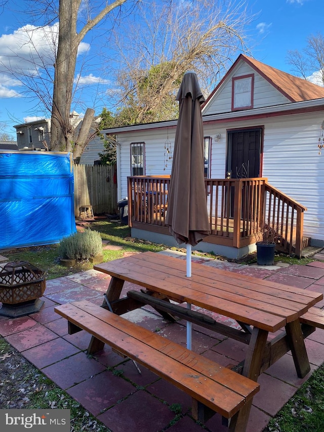 rear view of house with a deck and a fire pit