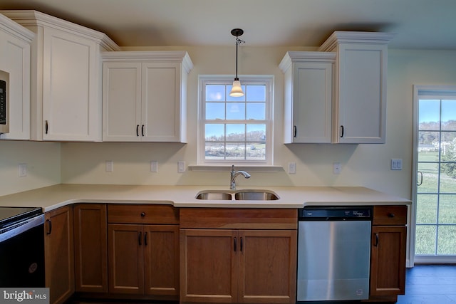 kitchen featuring electric range, dishwasher, light countertops, white cabinetry, and a sink