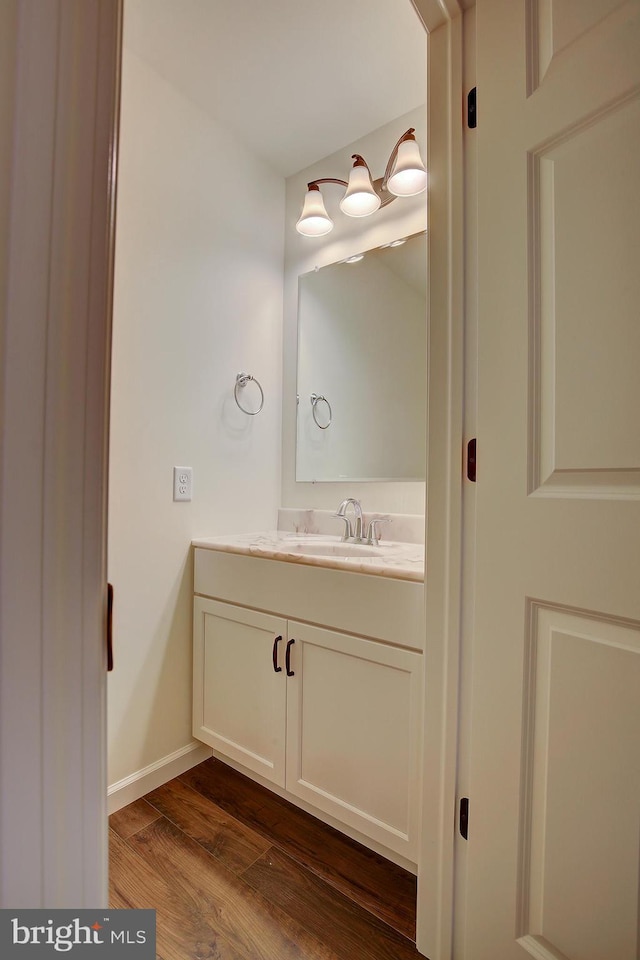 bathroom featuring baseboards, wood finished floors, and vanity