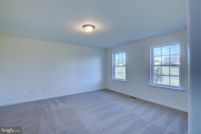 carpeted spare room with baseboards and visible vents