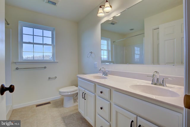 full bath with toilet, double vanity, a sink, and visible vents