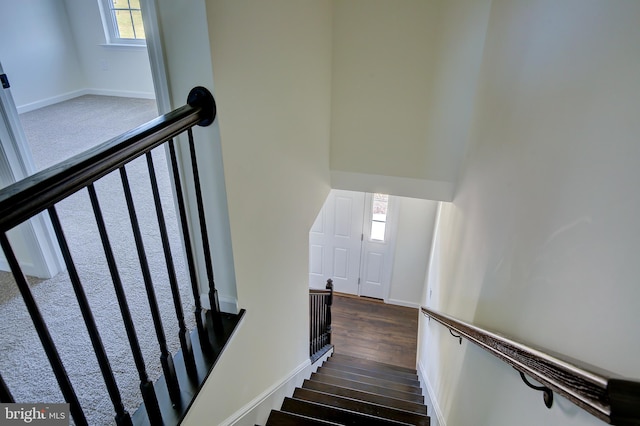 staircase with wood finished floors and baseboards