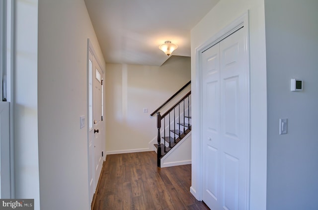 foyer with dark wood-style floors, stairs, and baseboards