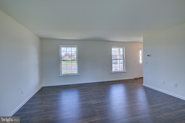 empty room with dark wood finished floors and baseboards