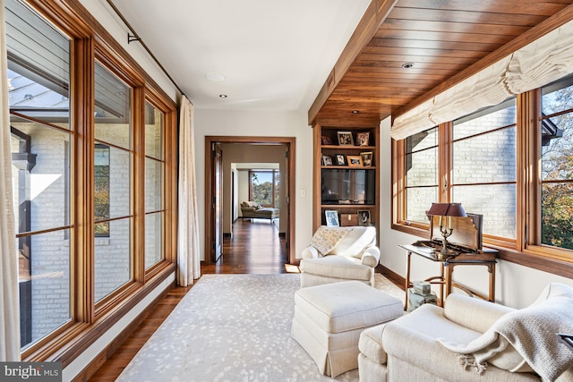 sitting room featuring wood ceiling, dark hardwood / wood-style floors, and built in shelves