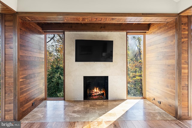 unfurnished living room featuring wooden walls and light hardwood / wood-style flooring