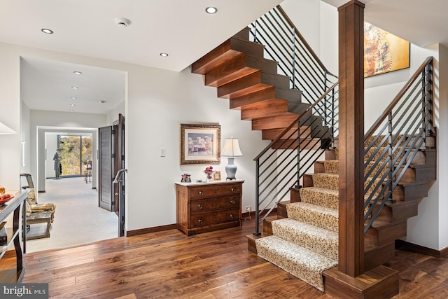 stairway with dark hardwood / wood-style floors