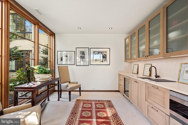 kitchen with sink, wine cooler, light carpet, and dishwasher