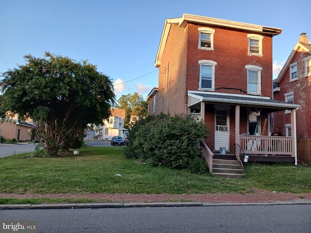 view of front of home with a front yard and covered porch