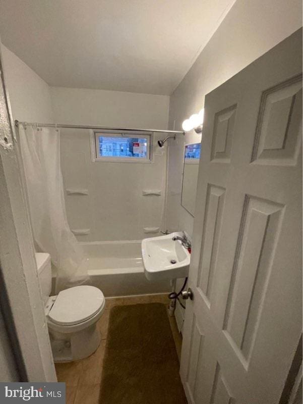 bathroom with tile flooring, toilet, and shower / bath combo