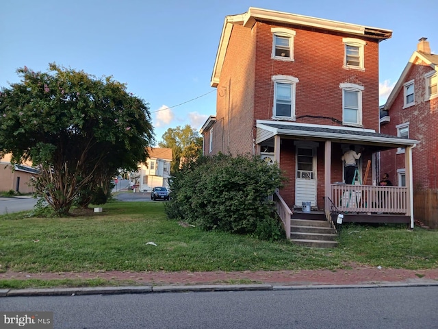 view of front of property with a porch and a front yard