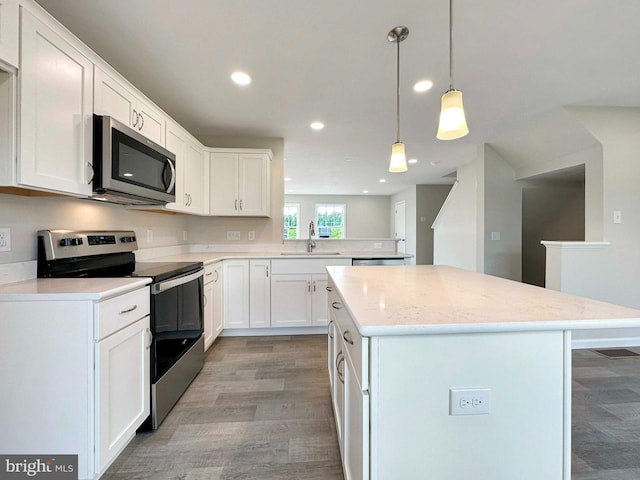 kitchen with sink, white cabinets, light wood-type flooring, and stainless steel appliances