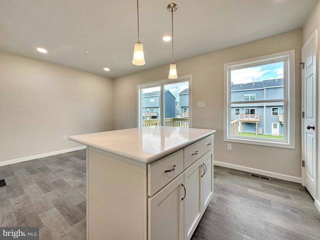 kitchen with a center island, a healthy amount of sunlight, and hardwood / wood-style floors