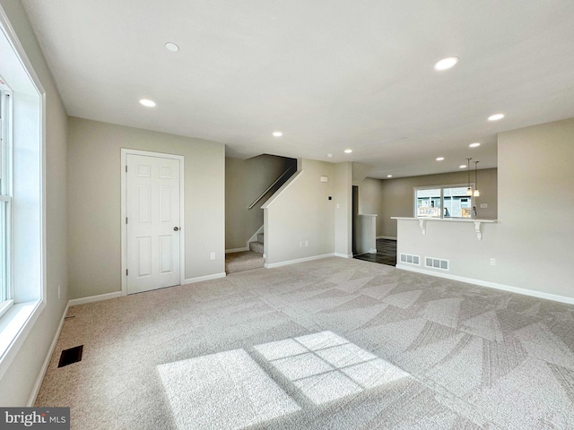 unfurnished living room featuring light carpet