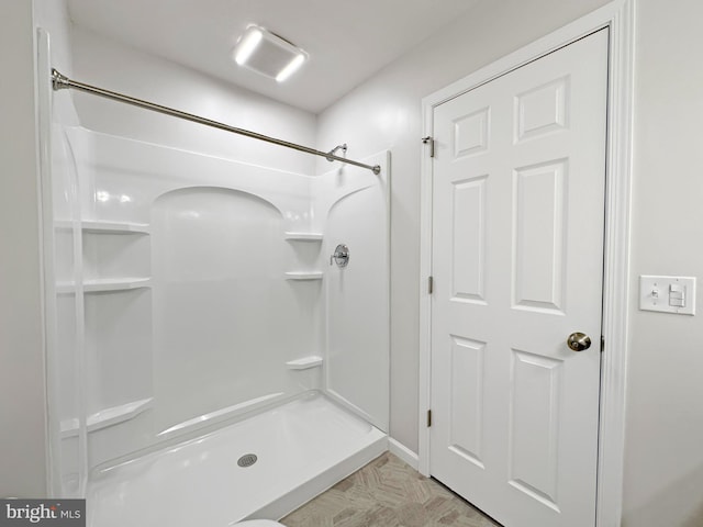 bathroom with a shower and parquet floors