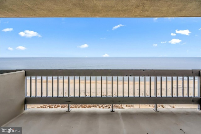 balcony featuring a beach view and a water view