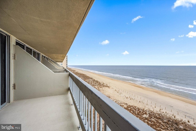 balcony featuring a water view and a beach view