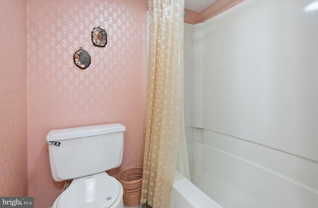 bathroom featuring shower / bath combo with shower curtain and toilet