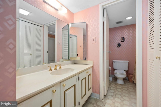 bathroom with tile flooring, large vanity, and toilet