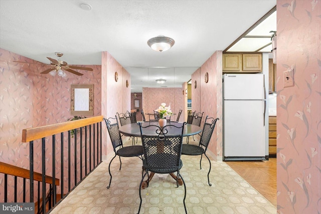 dining room with a textured ceiling, ceiling fan, and light tile floors