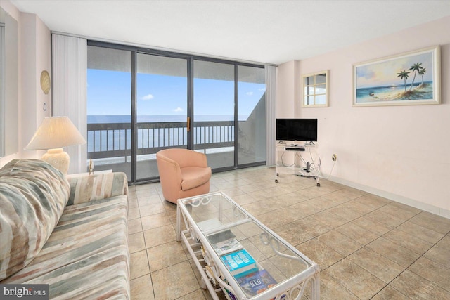 tiled living room featuring a water view, a wealth of natural light, and a wall of windows